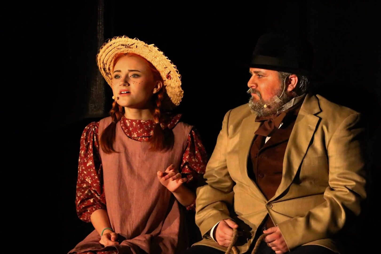 A girl and an old man sitting on the ground